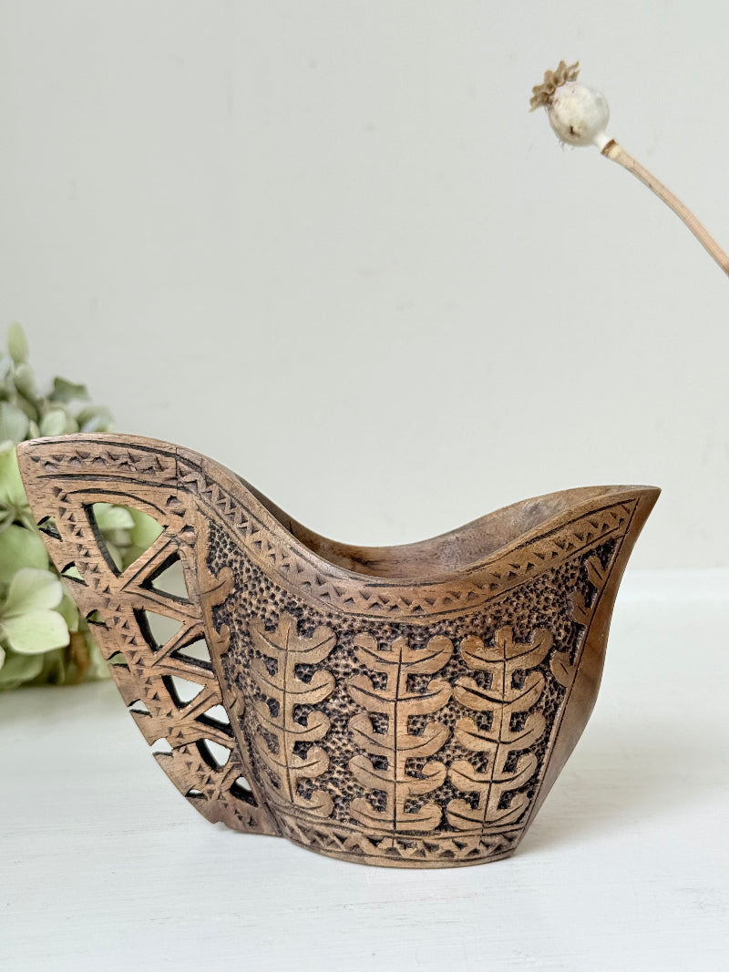 Pair of hand carved wooden jug and vase in contrasting light and dark tones, styled with dried poppy heads on a white surface.