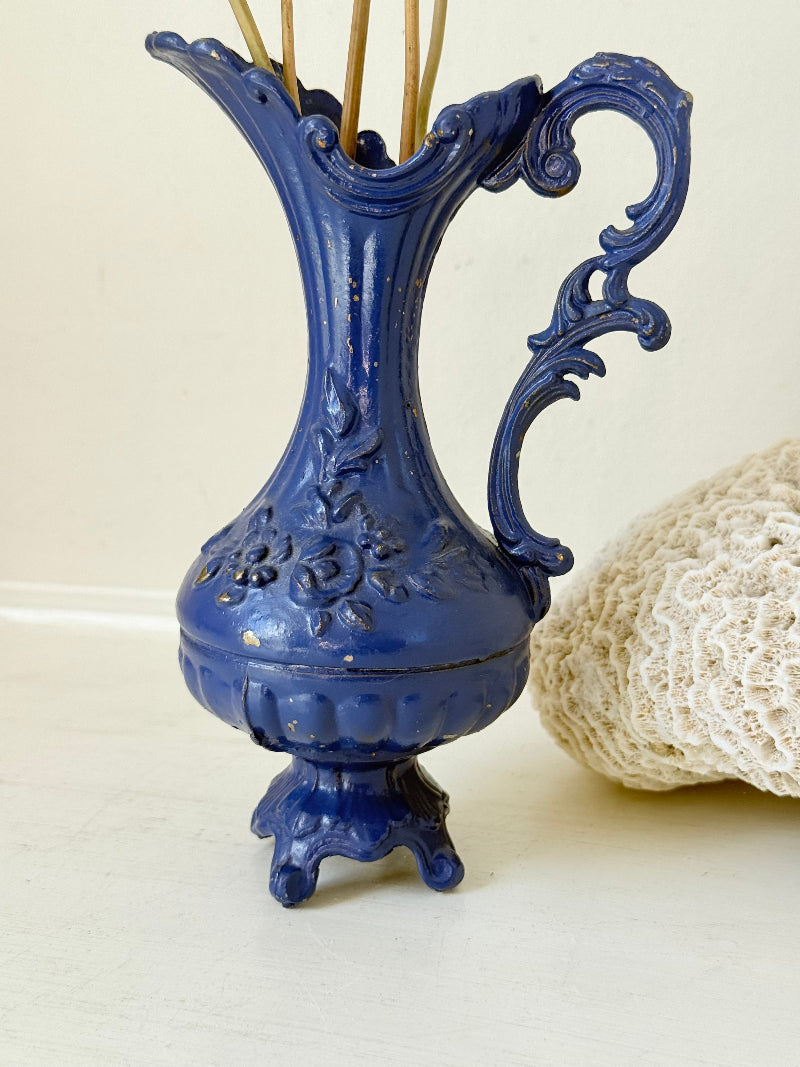 Blue vintage metal jug with ornate Rococo handle and relief decoration, shown on white background