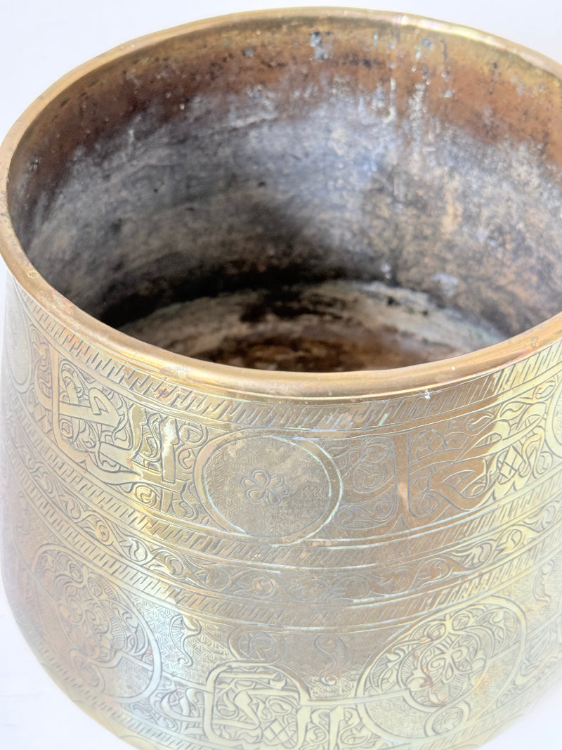 Large vintage brass pot with engraved decoration and aged patina, photographed on a white surface