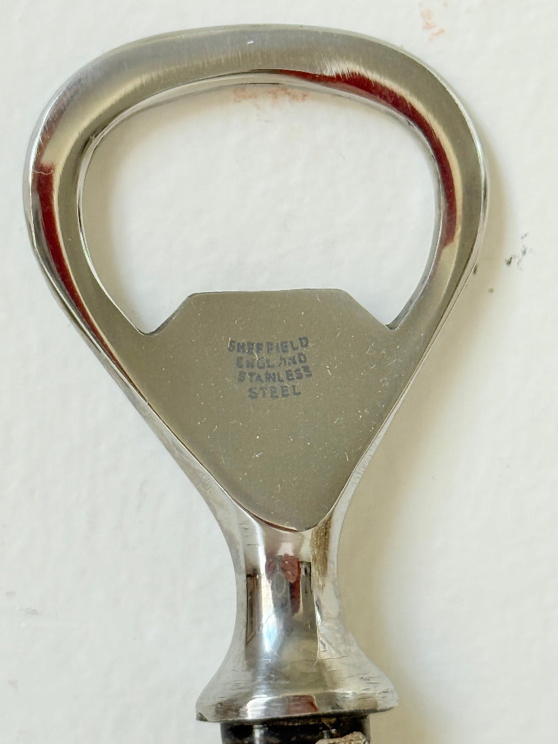 vintage antler handle bottle opener with stainless steel top photographed on white surface
