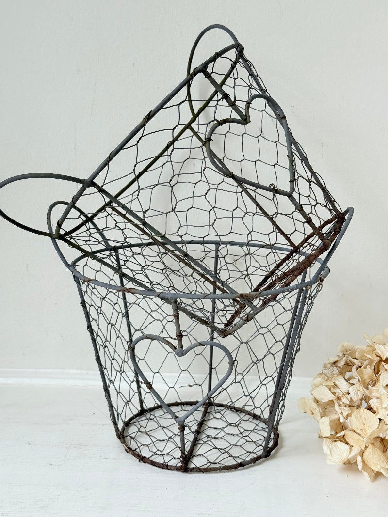 Pair of vintage decorative wire baskets with heart detail and aged patina photographed on a white surface