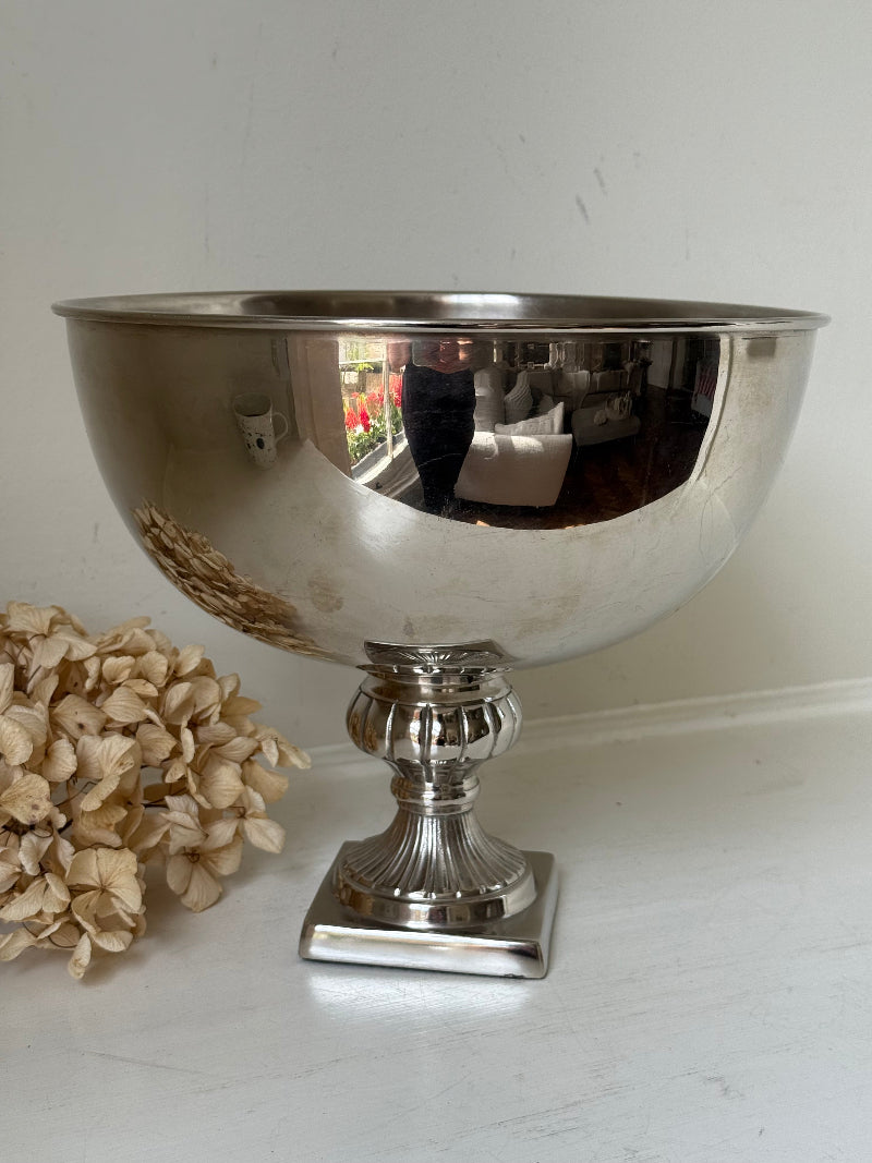 Vintage polished metal champagne bowl with pedestal base, photographed on a white surface