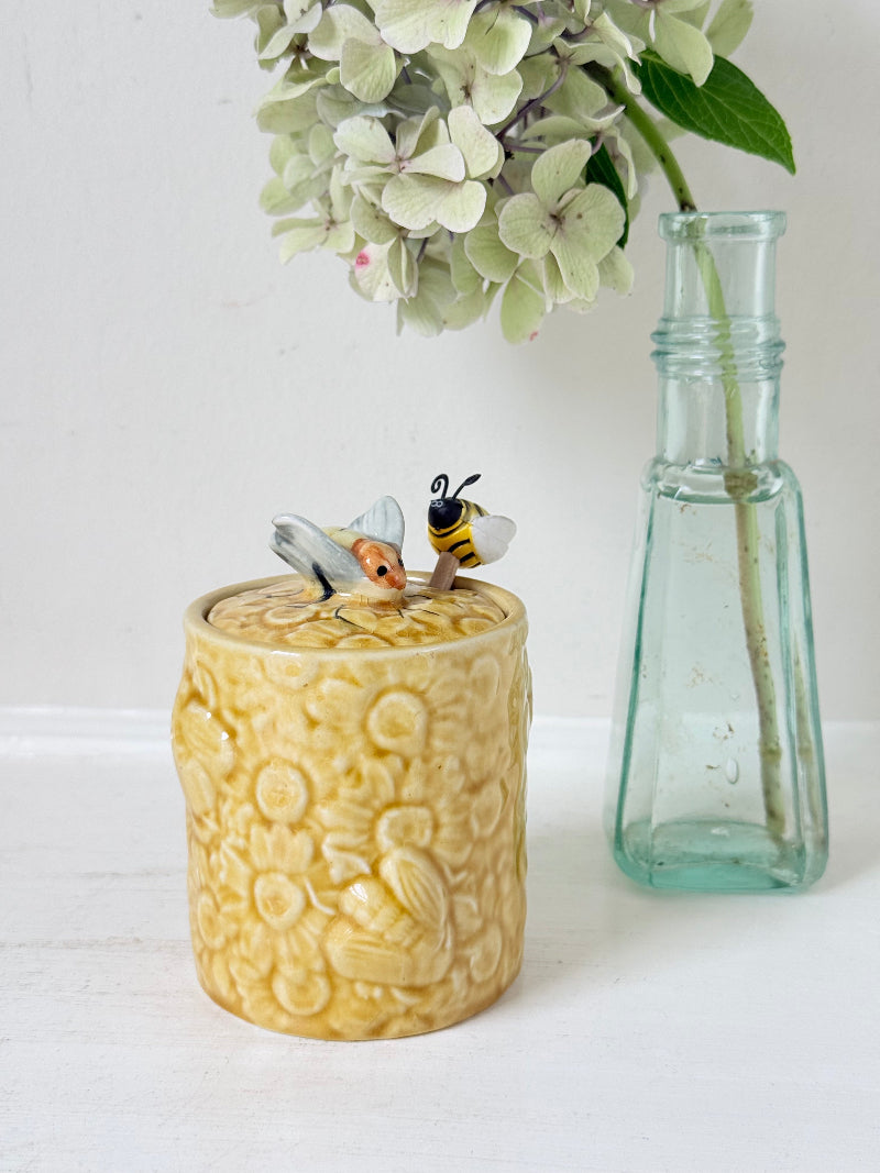 Secla pottery honey jar with lid, bee motif, and wooden honey spoon, made in Portugal, photographed on a white surface