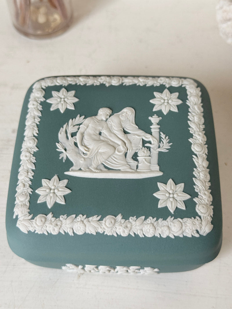 Vintage Wedgwood Jasperware teal green square lidded trinket box, decorated with white neoclassical figures and florets, styled with dried stems.