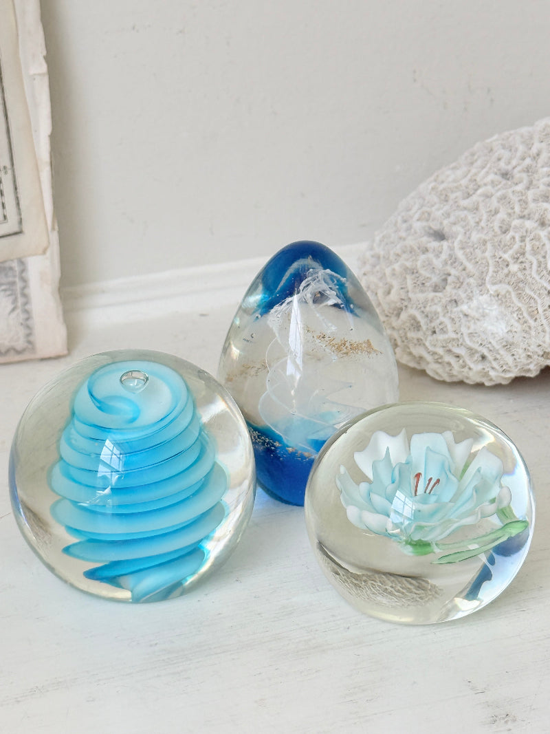 Trio of vintage turquoise blue glass paperweights with swirl, ribbed and floral detail in clear coloured glass