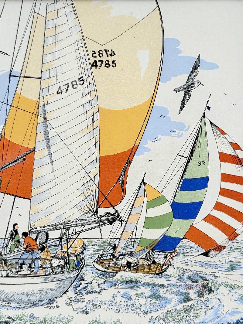 Vintage enamel artwork of sailing yachts with colourful striped sails in a regatta, framed in wood, photographed on white surface.
