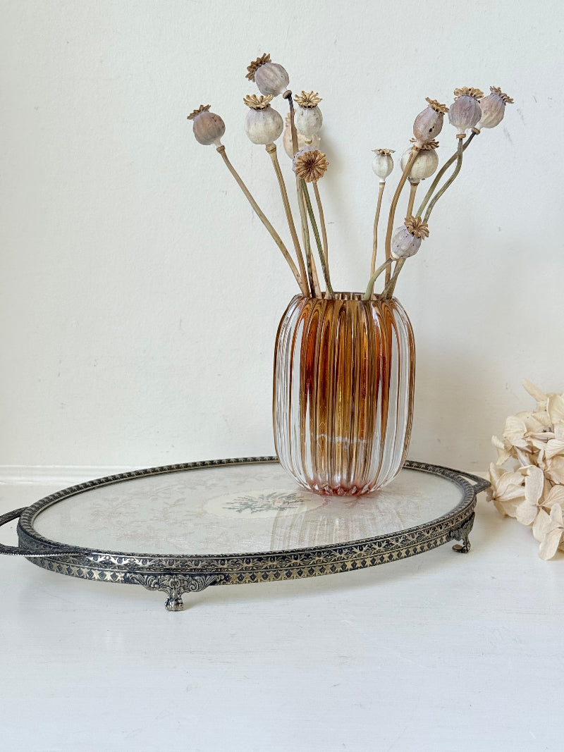 Vintage oval metal tray with pierced gallery sides, twin handles, and floral centre, photographed on white surface.