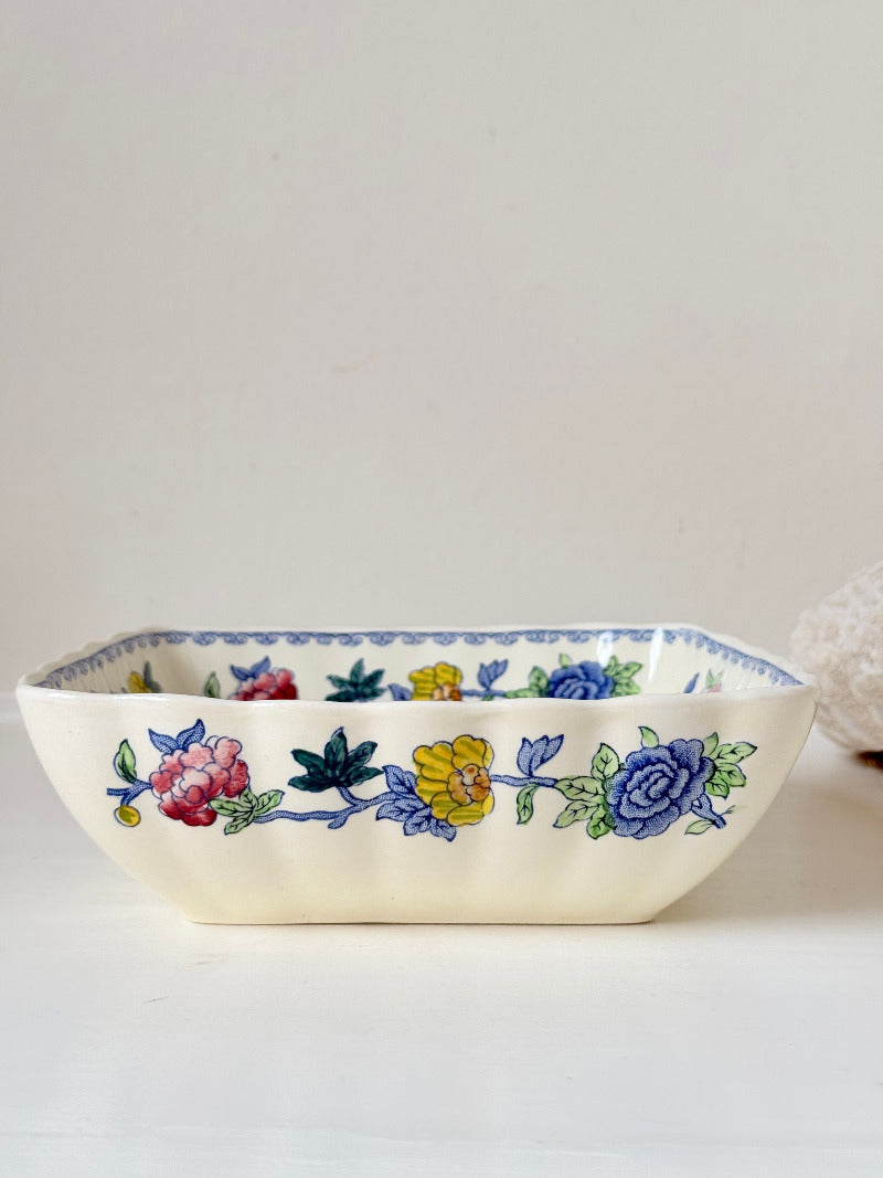Vintage Mason’s ironstone serving dish with square form and spring floral pattern in blue, pink, yellow, and green, photographed on a white surface