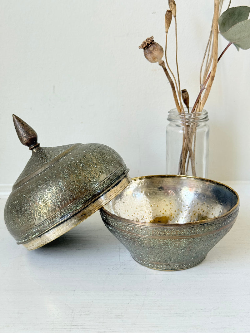 Indian Benares brass lidded jar with floral engraving and finial, photographed on a white surface