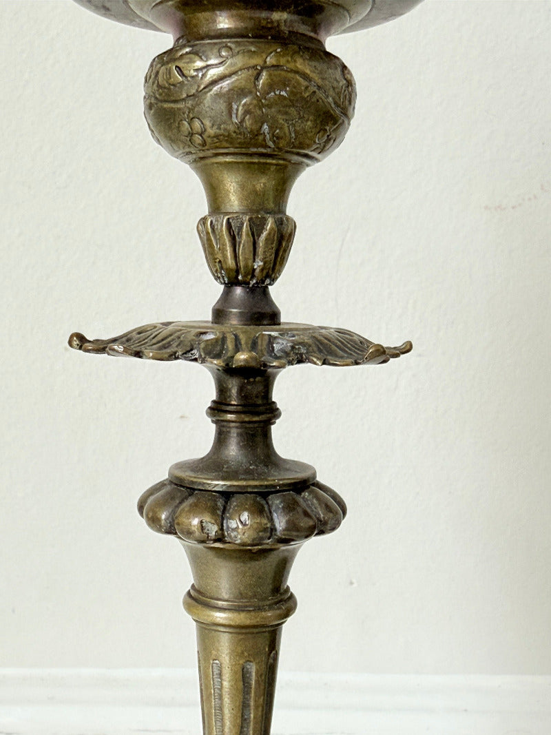 pair of antique brass candlesticks with turned detailing on white surface