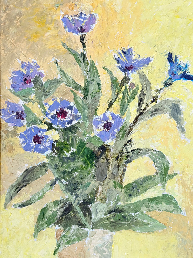 Vintage oil painting of cornflowers in a vase with yellow background in wooden frame photographed on a white surface
