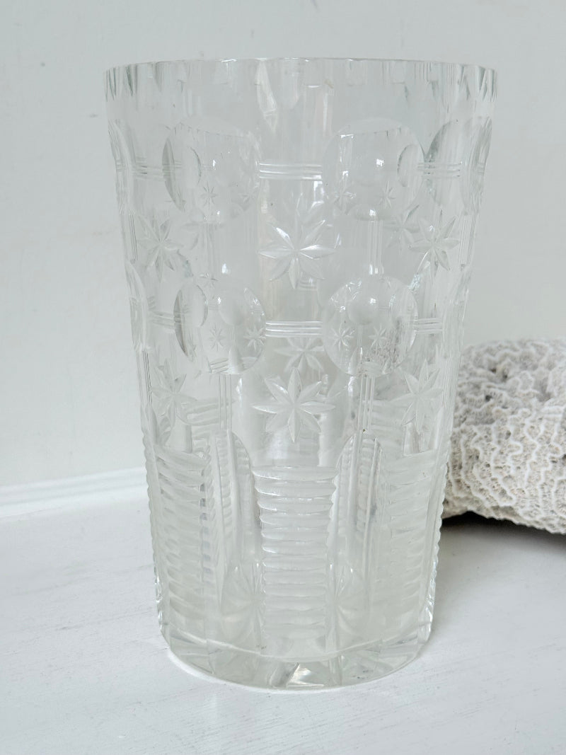 Vintage Stuart crystal cut glass vase with floral and star design, photographed on a white surface.