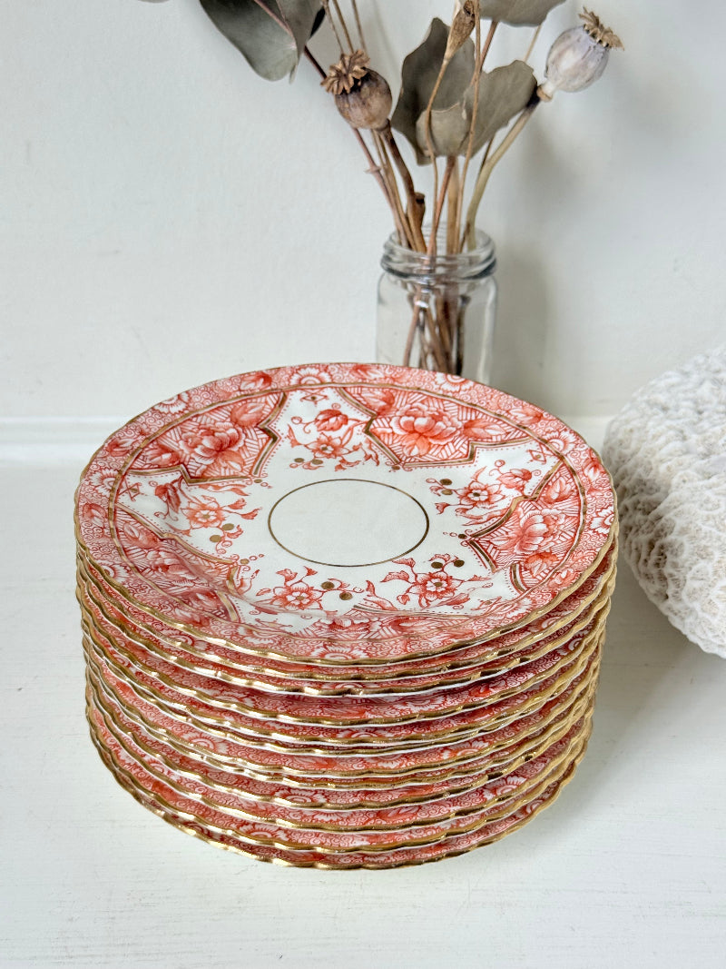 Set of 12 vintage coral transferware porcelain plates with scalloped edges and gold accents, 15 cm diameter, styled on a white surface.