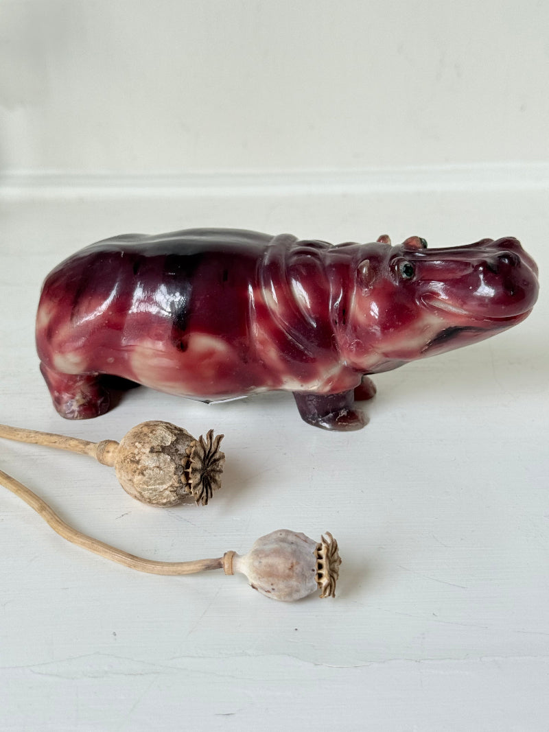 Red polished stone hippopotamus ornament displayed on a white background.