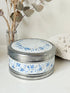 Vintage round shortbread tin with blue floral pattern on silver background, photographed on a white surface.