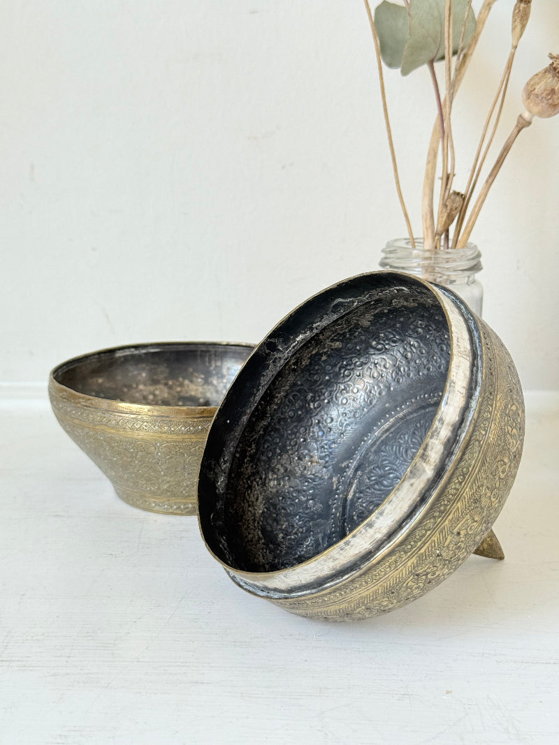 Indian Benares brass lidded jar with pointed finial and darkened interior, photographed on a white surface