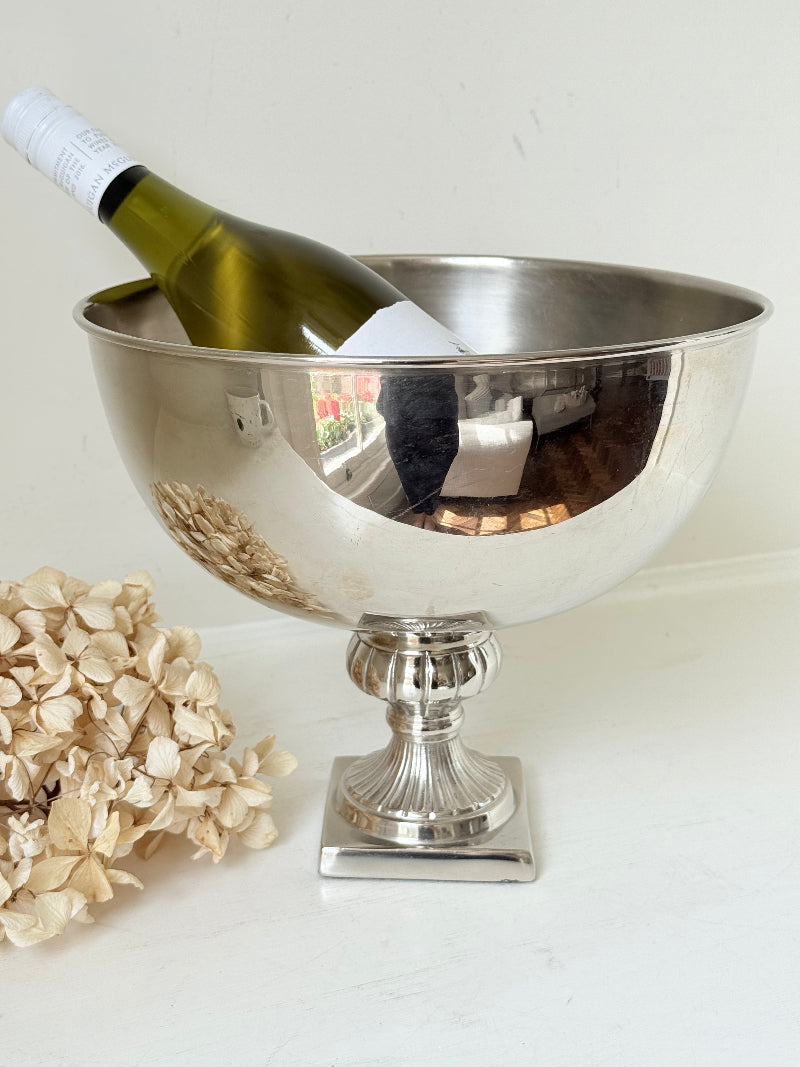 Vintage polished metal champagne bowl with pedestal base, photographed on a white surface
