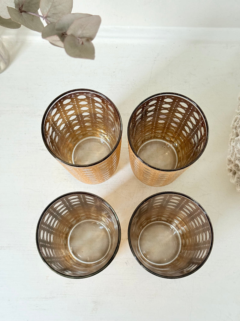Set of 4 vintage gold rattan effect glasses with pierced lattice sleeves, photographed on a white surface