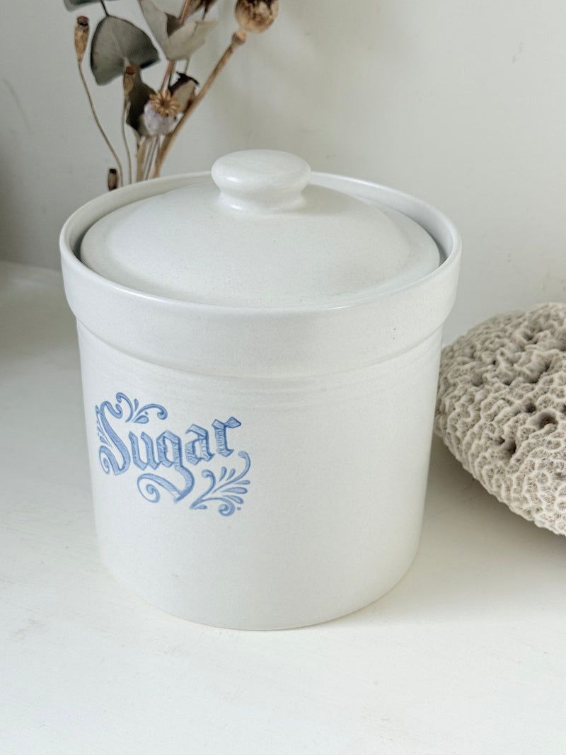 Pfaltzgraff Yorktowne stoneware sugar jar with blue floral motif and lid, photographed on a white surface