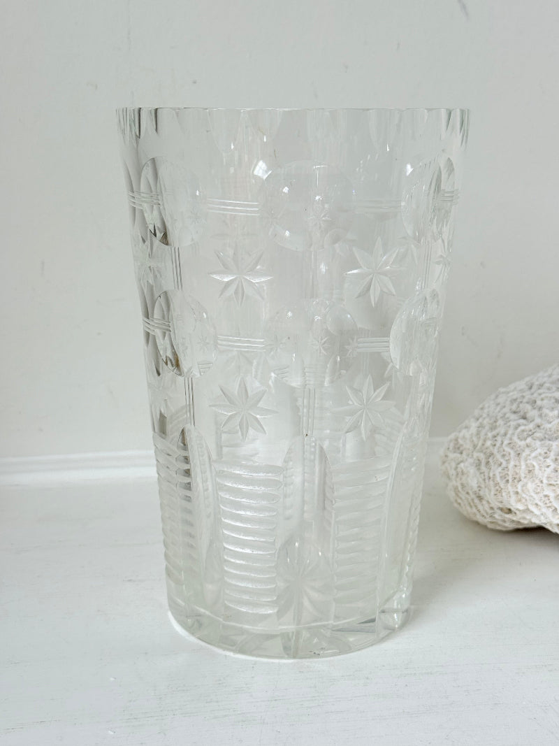 Vintage Stuart crystal cut glass vase with floral and star design, photographed on a white surface.