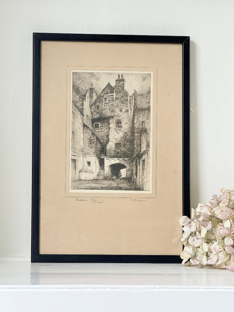 framed black and white print of edinburgh old town architecture photographed on white surface