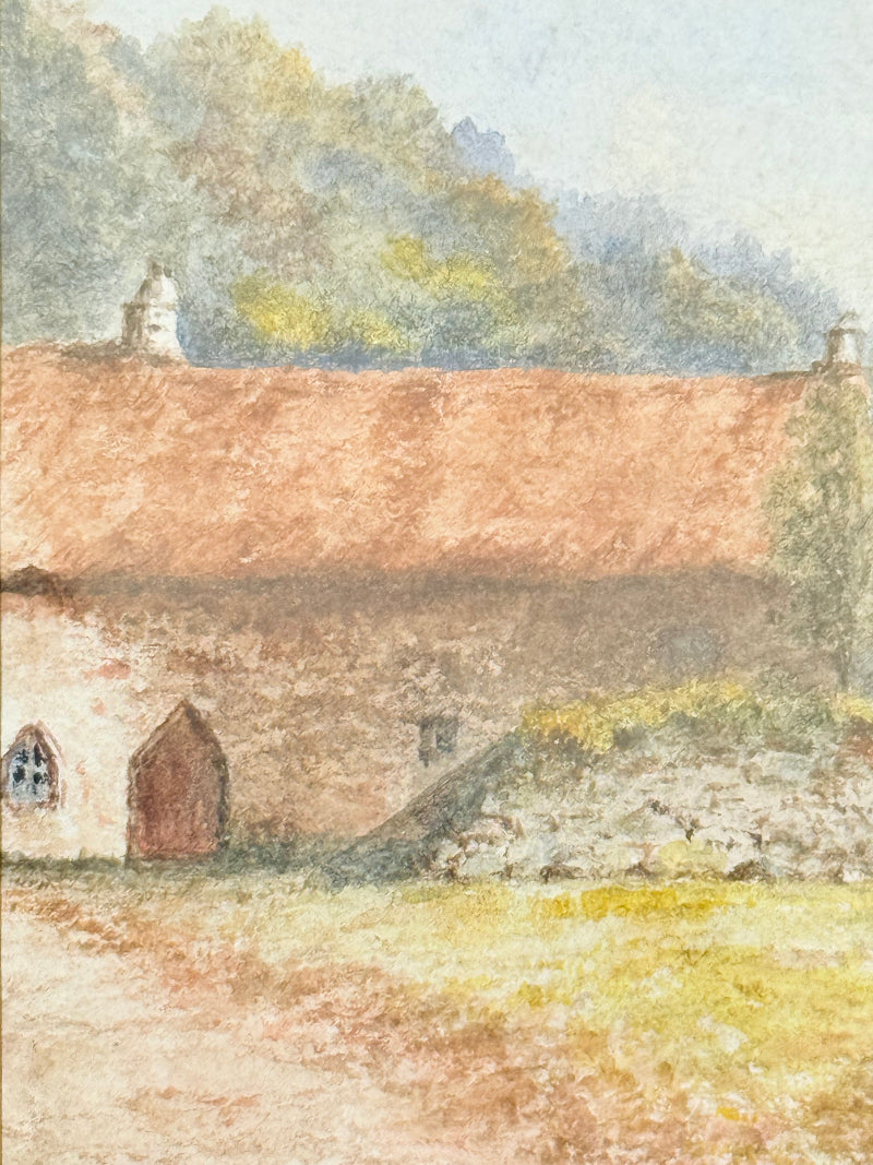 Framed vintage watercolour of countryside farm buildings with red roofs in gold frame photographed on a white surface