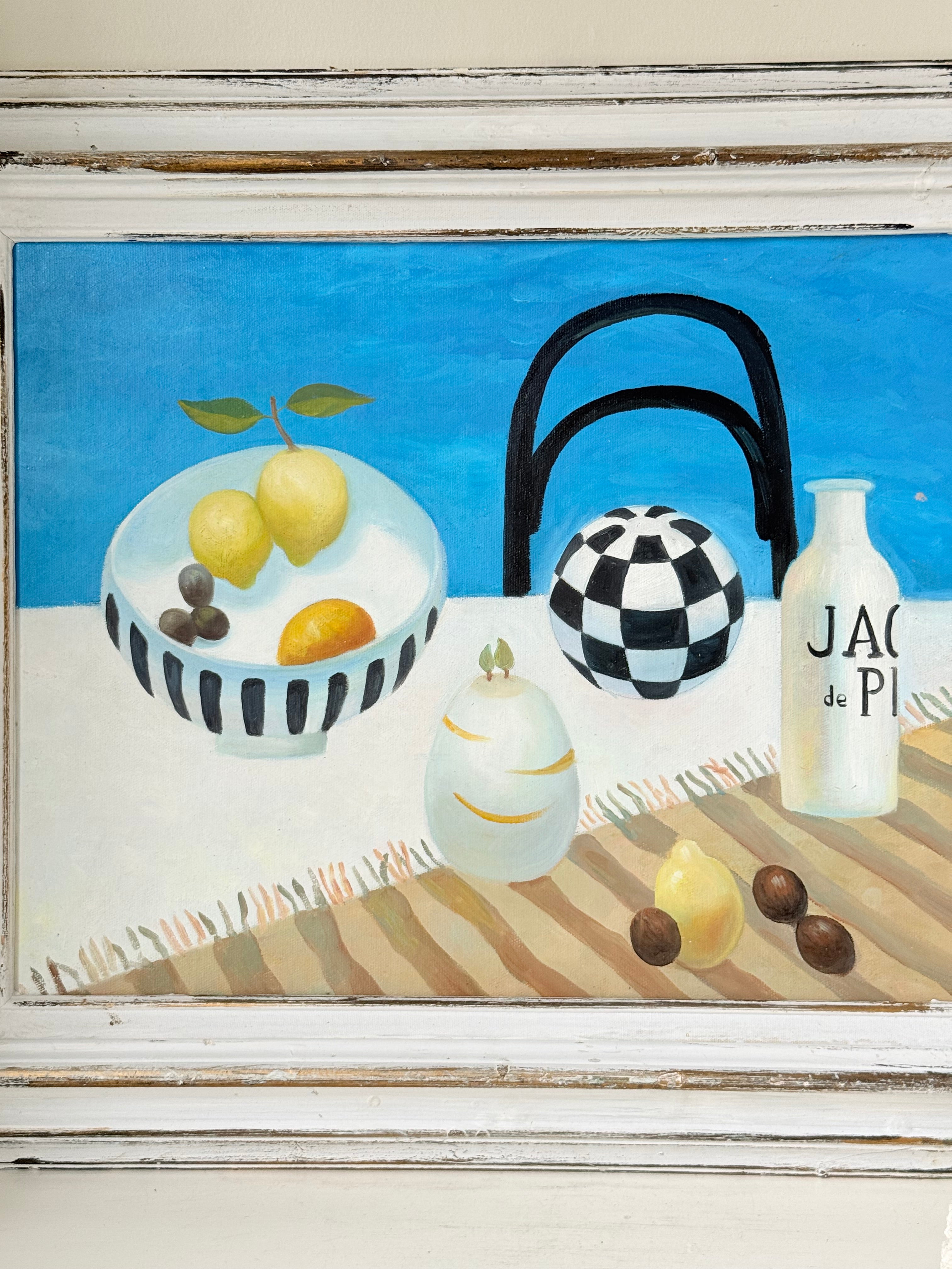 Still life oil painting showing fruit bowl and striped jug on a blue background, framed in white wood, photographed on a white surface.