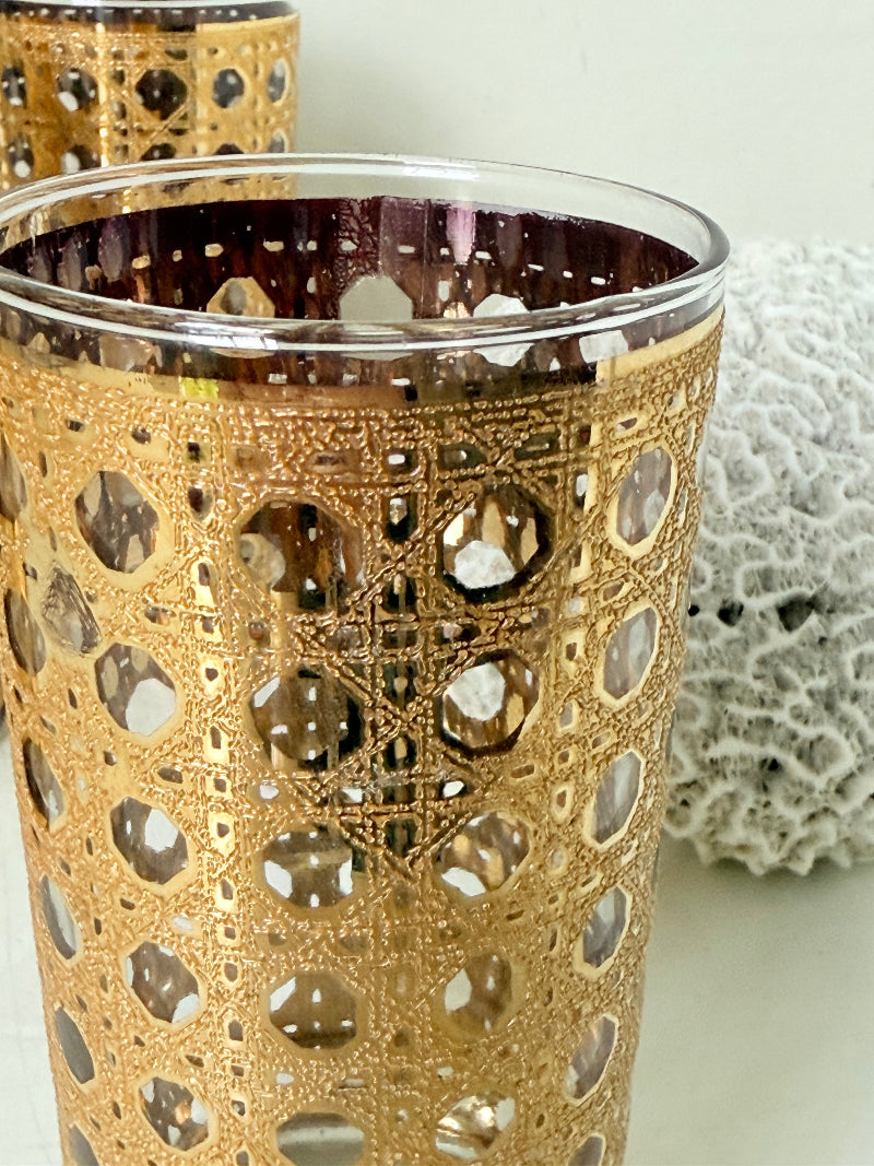 Set of 4 vintage gold rattan effect glasses with pierced lattice sleeves, photographed on a white surface