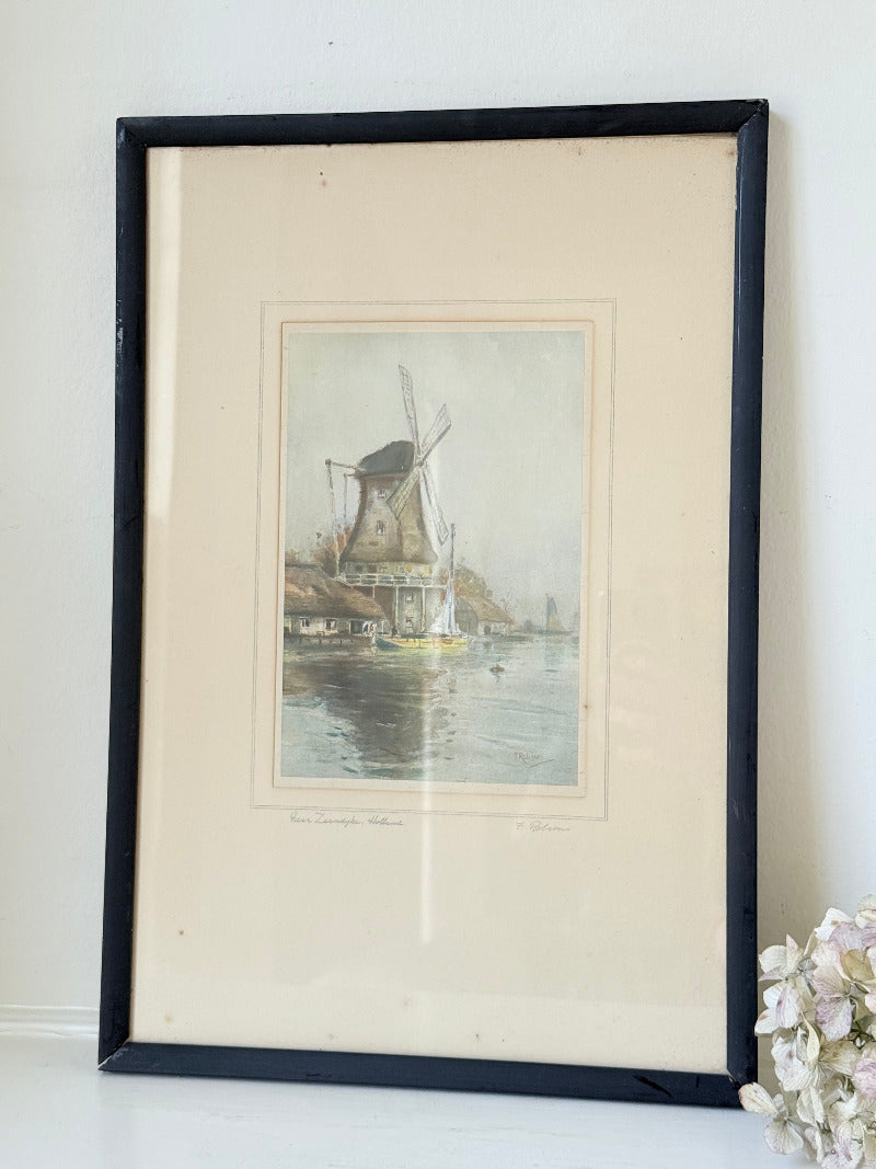 framed print of dutch windmill beside water in holland with reflection photographed on white surface