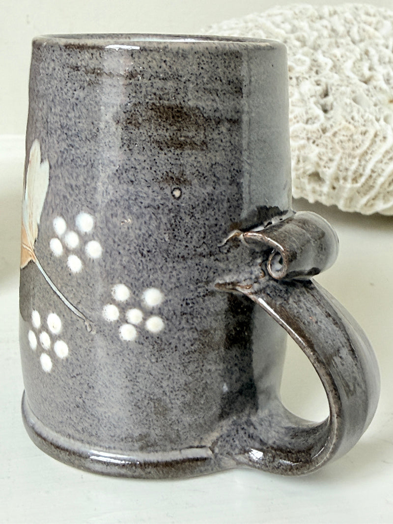 Pair of studio pottery mugs with complementary glazes photographed on a white surface
