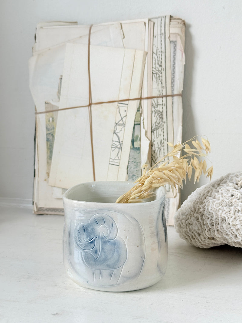 Hand painted ceramic pot with blue ram motif, pale grey off white glaze and handmade decorative form