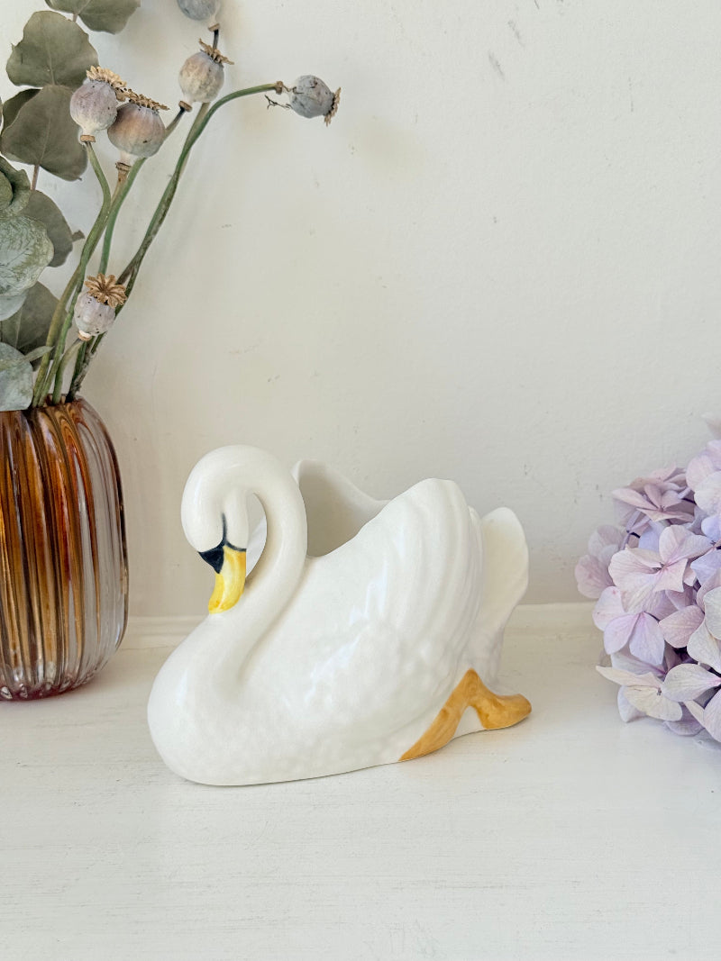 Vintage Sylvac swan planter in white ceramic with yellow beak and feet, styled on a white surface