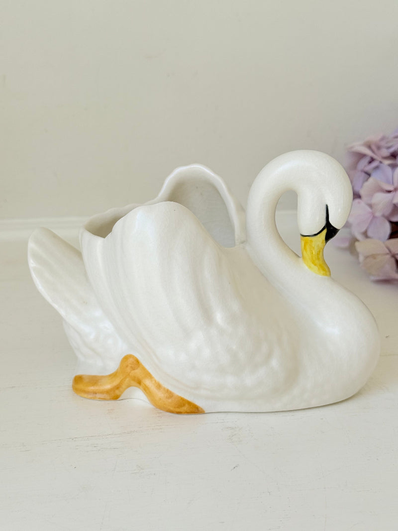 Vintage Sylvac swan planter in white ceramic with yellow beak and feet, styled on a white surface