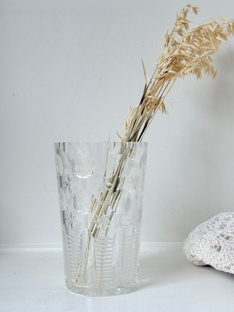 Vintage Stuart crystal cut glass vase with floral and star design, photographed on a white surface.