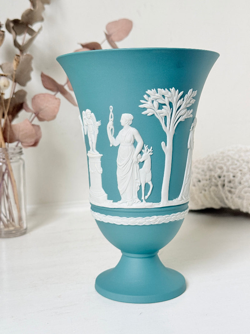 Large vintage Wedgwood Jasperware teal green pedestal vase decorated with white classical Muses figures and stylised trees, styled with dried stems.