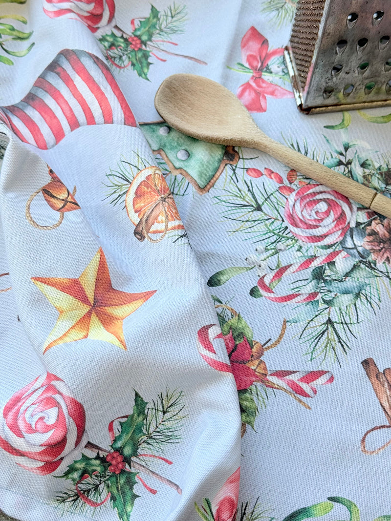 Blue Loft Christmas cotton tea towel with red striped stocking and festive motif pattern photographed on a white worktop.
