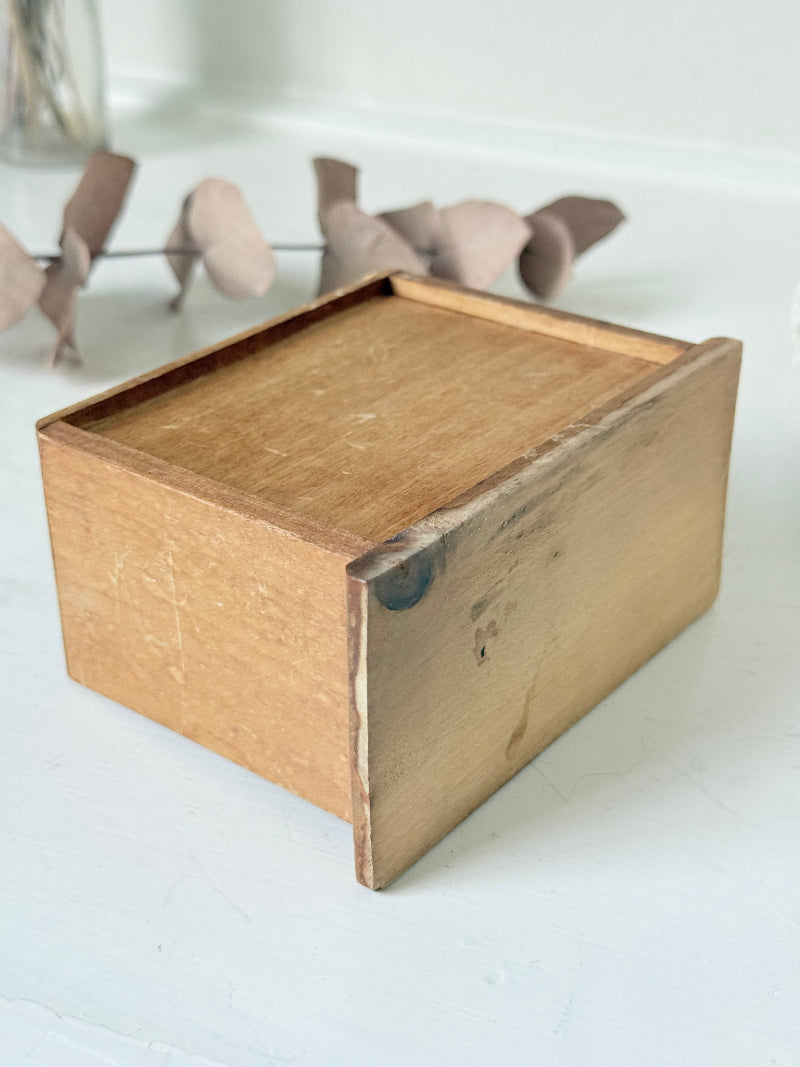 Vintage wooden telephone money box with printed lettering, photographed on a white surface