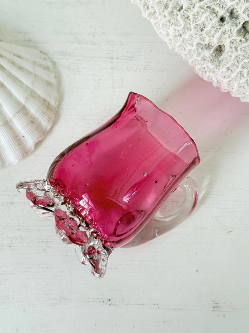 Antique cranberry glass cream jug with clear applied handle, crimped pedestal foot and deep pink hand blown glass body