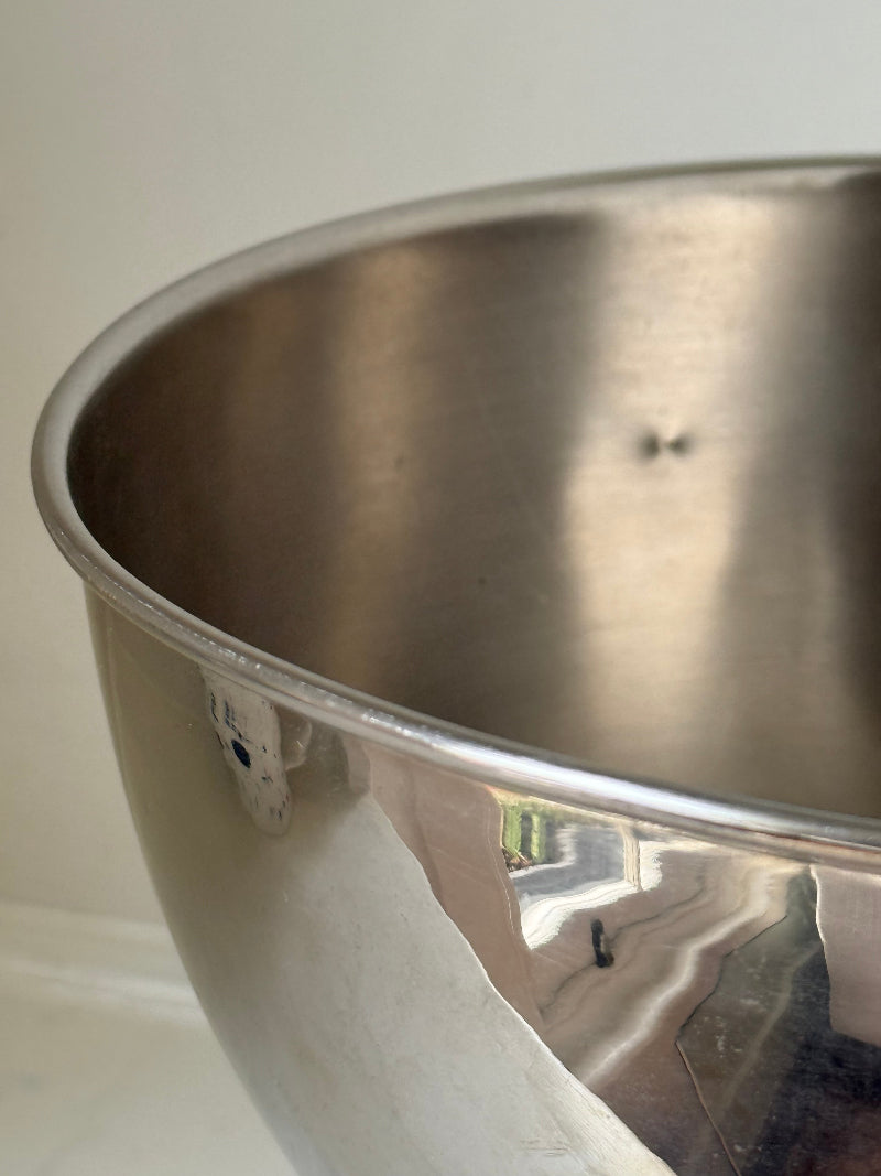 Vintage polished metal champagne bowl with pedestal base, photographed on a white surface