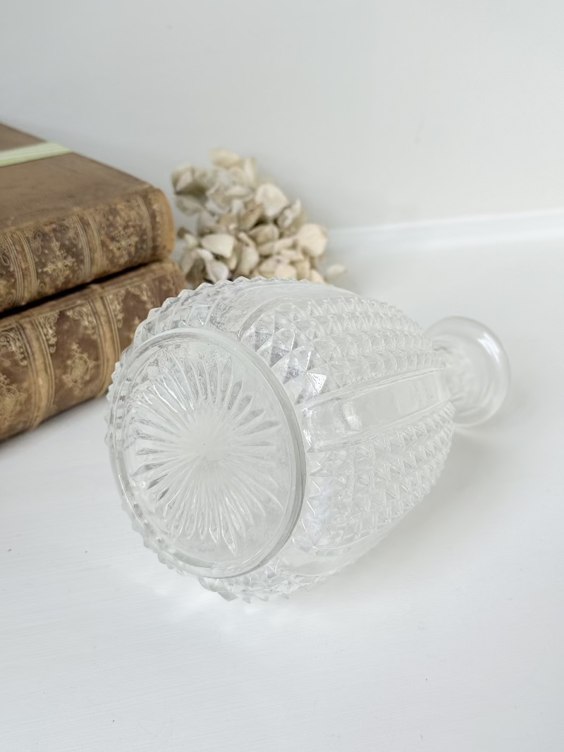Vintage clear glass vase with textured surface, styled with dried flowers on a white background