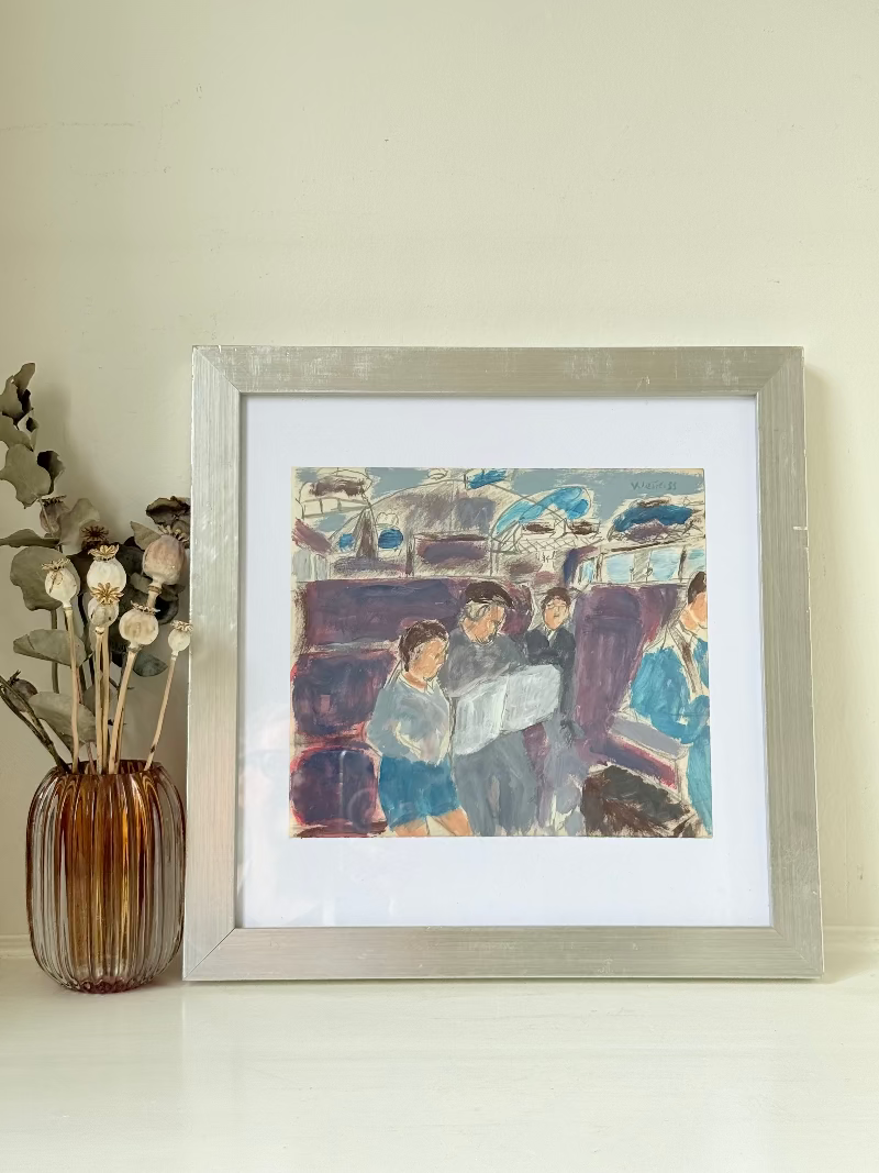 Mixed media painting by Watkiss of figures in a train carriage, framed in white, photographed on a white surface