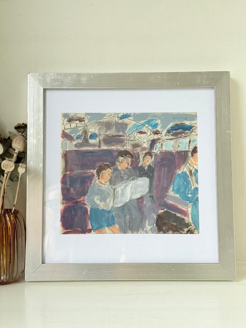 Mixed media painting by Watkiss of figures in a train carriage, framed in white, photographed on a white surface