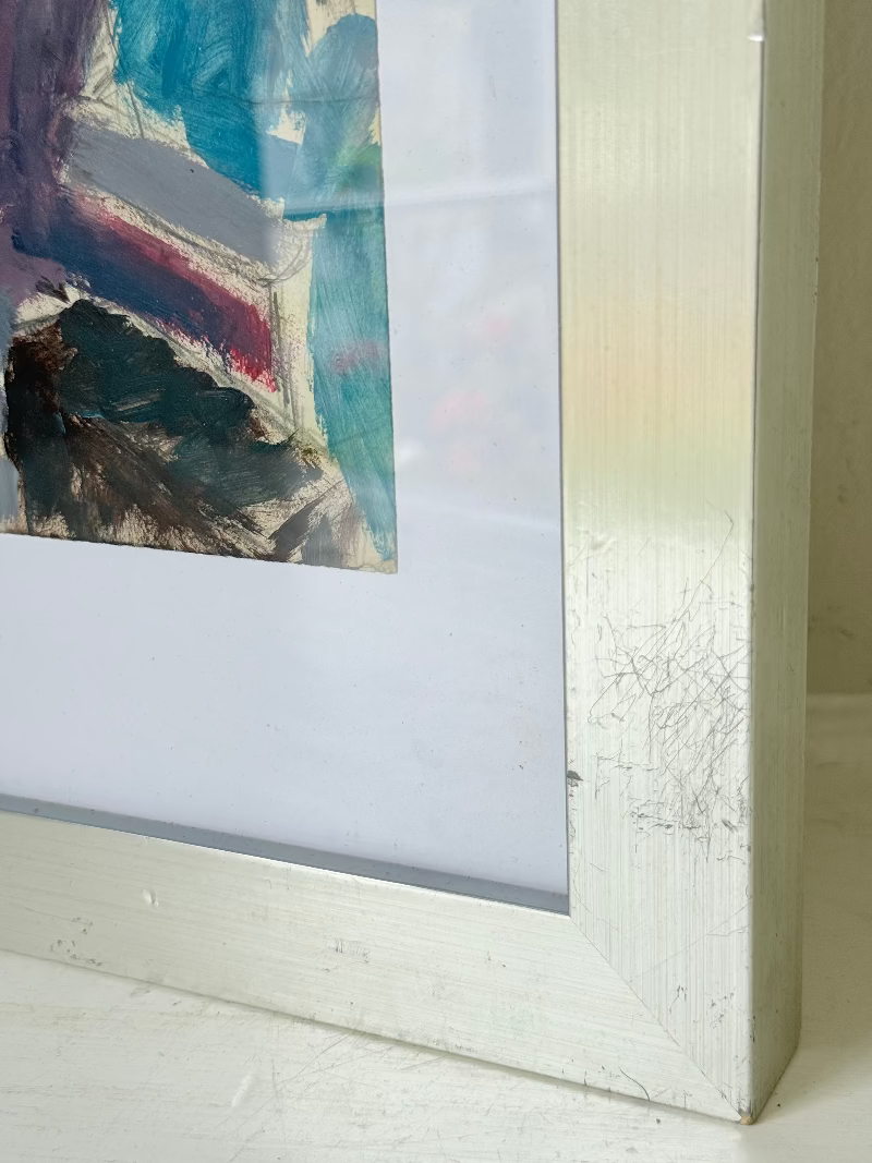 Mixed media painting by Watkiss of figures in a train carriage, framed in white, photographed on a white surface