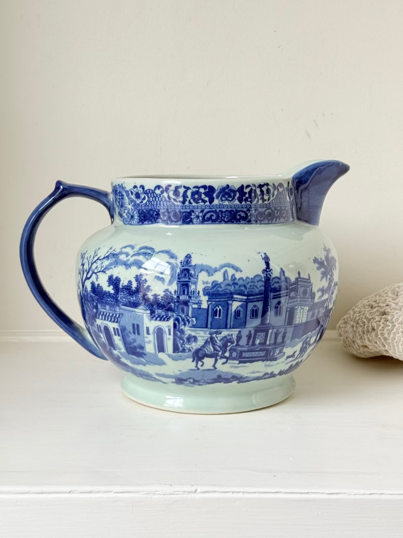 Vintage large ironstone jug with blue and white transferware decoration, photographed on a white surface