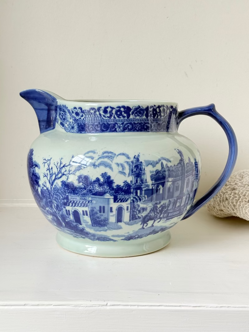 Vintage large ironstone jug with blue and white transferware decoration, photographed on a white surface