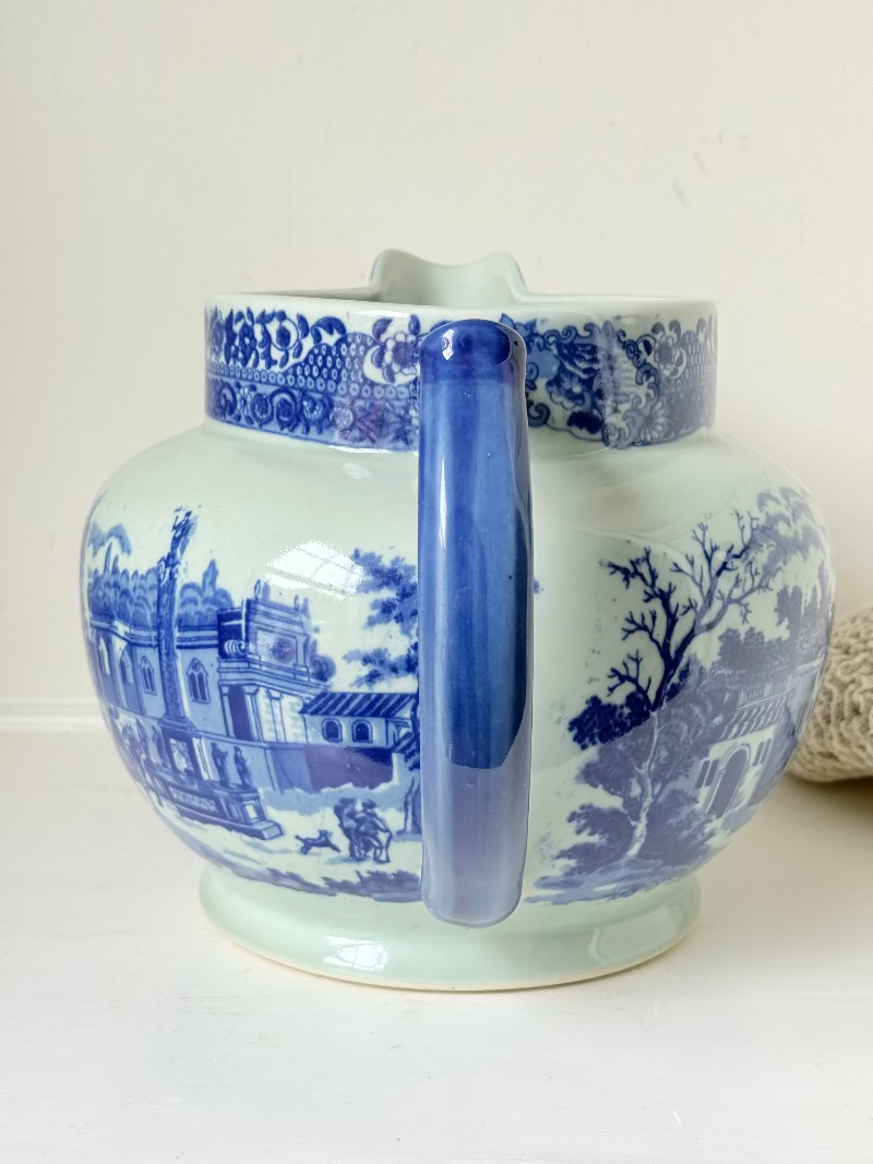 Vintage large ironstone jug with blue and white transferware decoration, photographed on a white surface