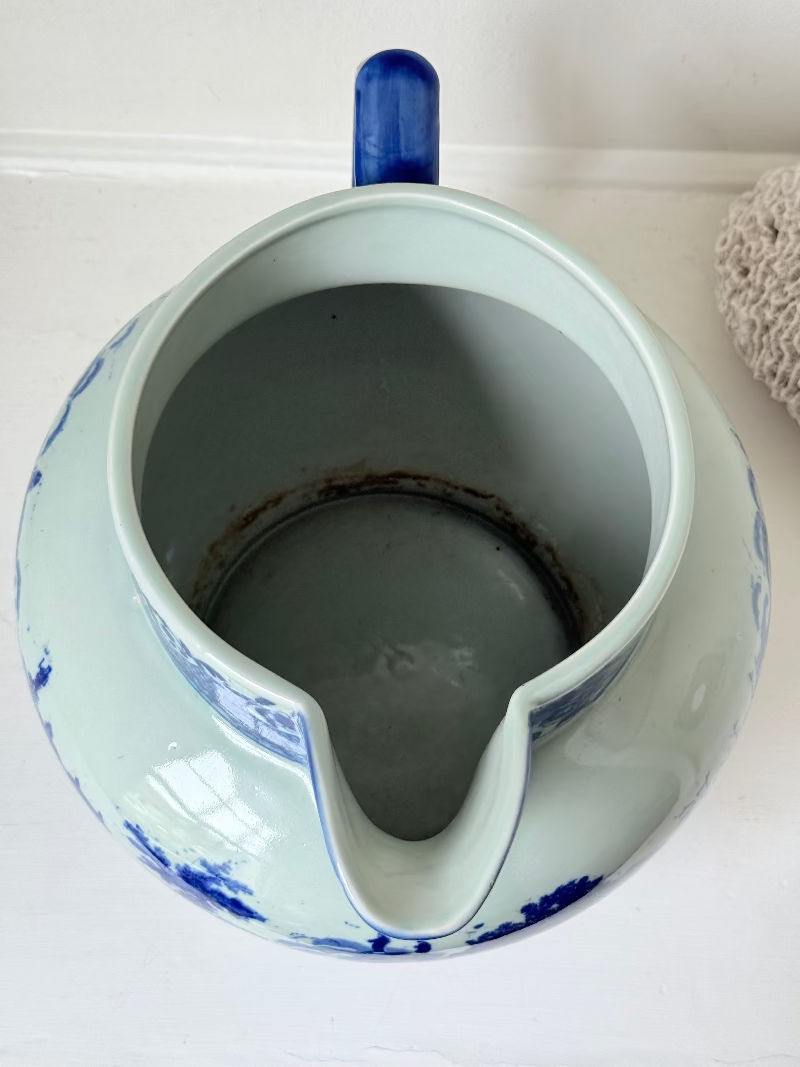 Vintage large ironstone jug with blue and white transferware decoration, photographed on a white surface