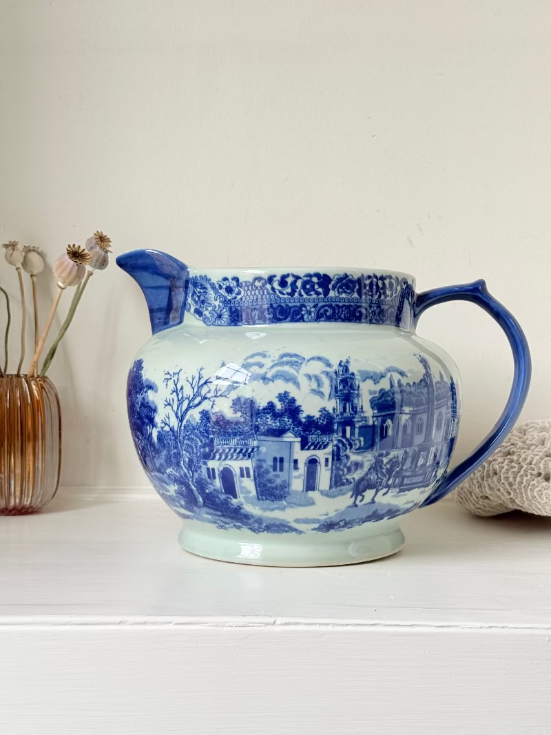 Vintage large ironstone jug with blue and white transferware decoration, photographed on a white surface