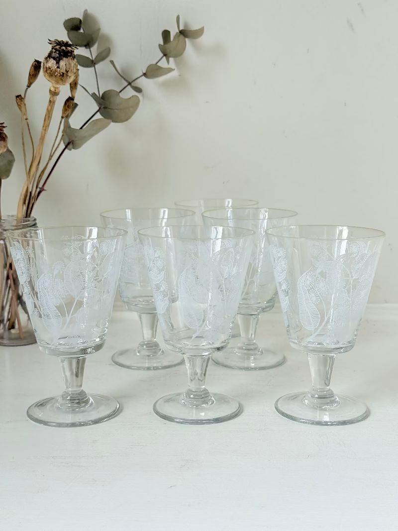 Set of six vintage wine glasses with white floral printed design, photographed on white surface.