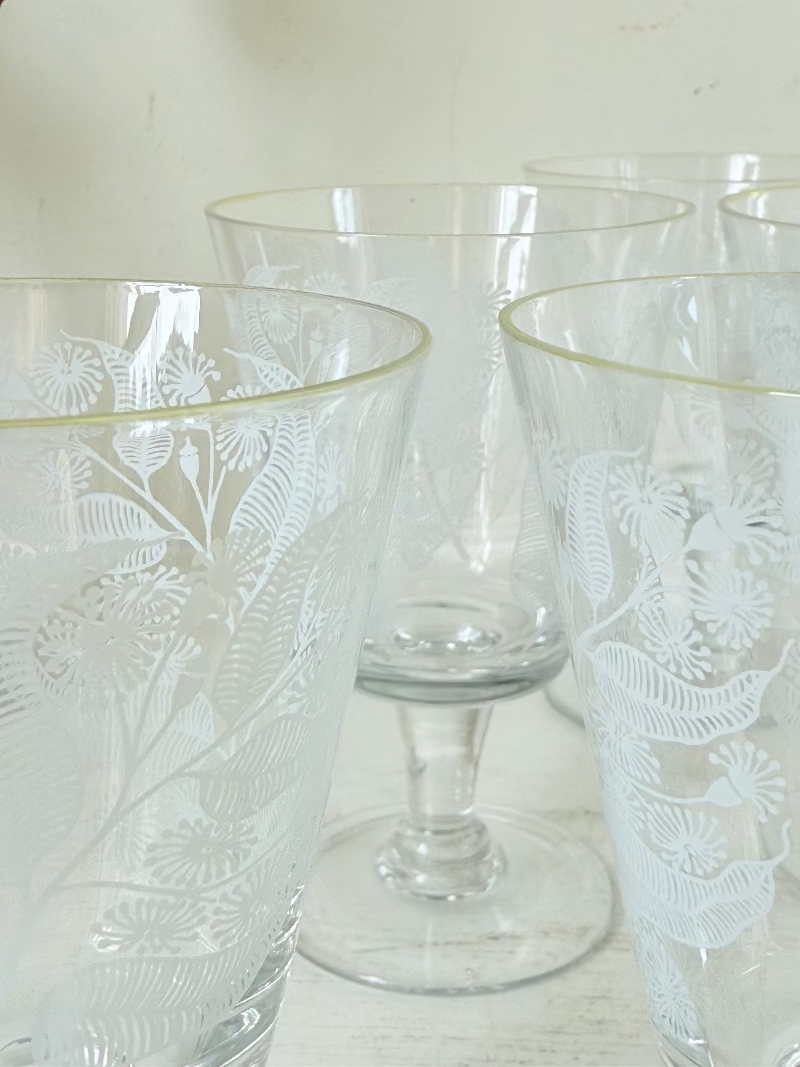 Set of six vintage wine glasses with white floral printed design, photographed on white surface.
